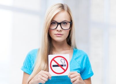 момиче, което държи знак за забрана за пушене на входа